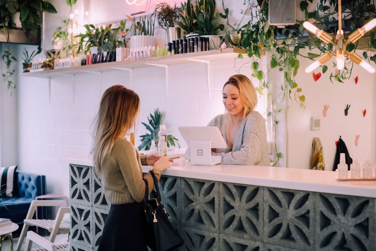 Two women at a counter talking to a customer